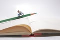 A Girl rides on a motorcycle over open diary book. Travel concept