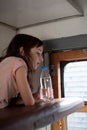 Girl in a rides in an old train. Nearby is a bottle of water Royalty Free Stock Photo