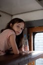 Girl in a rides in an old train. Nearby is a bottle of water Royalty Free Stock Photo