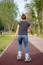 A girl rides roller skates in a city Park in summer Royalty Free Stock Photo