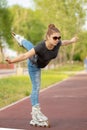 A girl rides roller skates in a city Park in summer