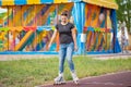 A girl rides roller skates in a city Park in summer Royalty Free Stock Photo