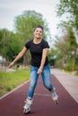 A girl rides roller skates in a city Park in summer