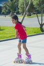 The girl rides on roller skates in the park