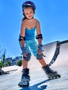 Girl rides on roller skates in skatepark.