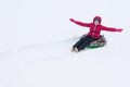 The girl rides on a round inflatable sled in the white snow, leaves traces Royalty Free Stock Photo