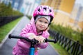 Girl rides a small Bicycle on a wet road