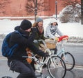Girl riding a bicycle with a basket in the winter.
