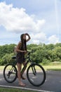 Girl riding a bicycle. Side view. Forest and clouds in the background