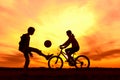 Girl riding bike in countryside, boy playing with ball outdoors Royalty Free Stock Photo