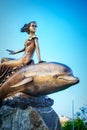 A girl riding a dolphin monument in Novorossiysk