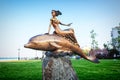 A girl riding a dolphin monument in Novorossiysk