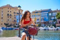 Girl riding a foldable e-bike in a Mediterranean marina