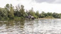 Girl riding gray horse down the calm river water Royalty Free Stock Photo