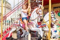 Girl riding on a merry go round. Little girl playing on carousel, summer fun, happy childhood and vacation concept Royalty Free Stock Photo