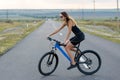 A girl riding a mountain bike on an asphalt road, beautiful portrait of a cyclist Royalty Free Stock Photo