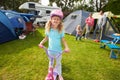 Girl Riding Scooter Whilst On Family Camping Holiday