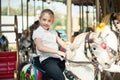 A girl riding a toy horse on a carousel in the park Royalty Free Stock Photo