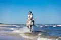 Girl galopading on a white horse in the sea Royalty Free Stock Photo