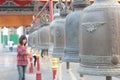 Girl ringing a row of temple bells at Wat Thai Royalty Free Stock Photo