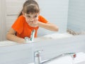 Girl rinses her mouth after brushing her teeth