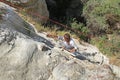 The girl rises by the steep hill by means of rope. Rock formation at the end of the Zemi valley between Gereme and Uchisar, Cappad Royalty Free Stock Photo