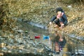 Girl on the river bank plays Paper Boat