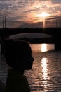 girl on river embankment in evening. Profile portrait of girl resting and meditating Royalty Free Stock Photo