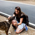 Girl on a roadside with a homeless dog, traveling together Royalty Free Stock Photo