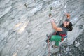 Girl rock climber climbing challenging route on the cliff