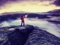 Girl on rocky edge above foggy cloud  illuminated misty world Royalty Free Stock Photo