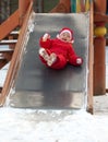 Girl roll down on playground slide