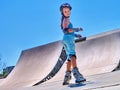 Girl roller in skates park. Child wear safety helmet do sport exercise.