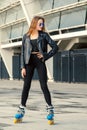 Girl on rollerblades standing in building background. Royalty Free Stock Photo