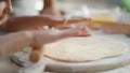 Girl rolling dough on kitchen. Mother and daughter preparing dough at home