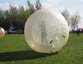 A girl is rolling down in a giant bubble ball for outdoor inflatable games