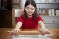 An eight year old girl rolling pastry