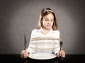 Girl roped sitting at table in front of a dish Royalty Free Stock Photo