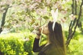 Girl with rosy bunny ears smelling sakura flowers from tree Royalty Free Stock Photo