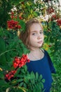 a girl with a rowan tree. Portrait of a 13-year-old teenage girl with orange rowan berries in the city at sunset