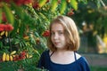 a girl with a rowan tree. Portrait of a 13-year-old teenage girl with orange rowan berries in the city at sunset