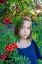 a girl with a rowan tree. Portrait of a 13-year-old teenage girl with orange rowan berries in the city at sunset