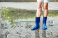 Girl in rubber boots standing in a puddle after a rain Royalty Free Stock Photo