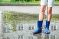 Girl in rubber boots standing in a puddle after a rain Royalty Free Stock Photo