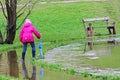 Girl in rubber boots with umbrella walking through the puddles Royalty Free Stock Photo