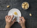 The girl rubs garlic on a special grater on a wooden table