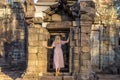A girl in the ruins of Ta Prohm temple in Angkor complex, Cambodia