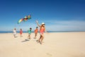 Girl run with kite and group of kids on the beach Royalty Free Stock Photo