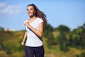 Girl runner runs along in nature in summer.