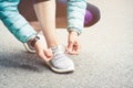 Girl runner tying laces for jogging her shoes on road in a park. Running shoes, Shoelaces. Exercise concept. Sport Royalty Free Stock Photo